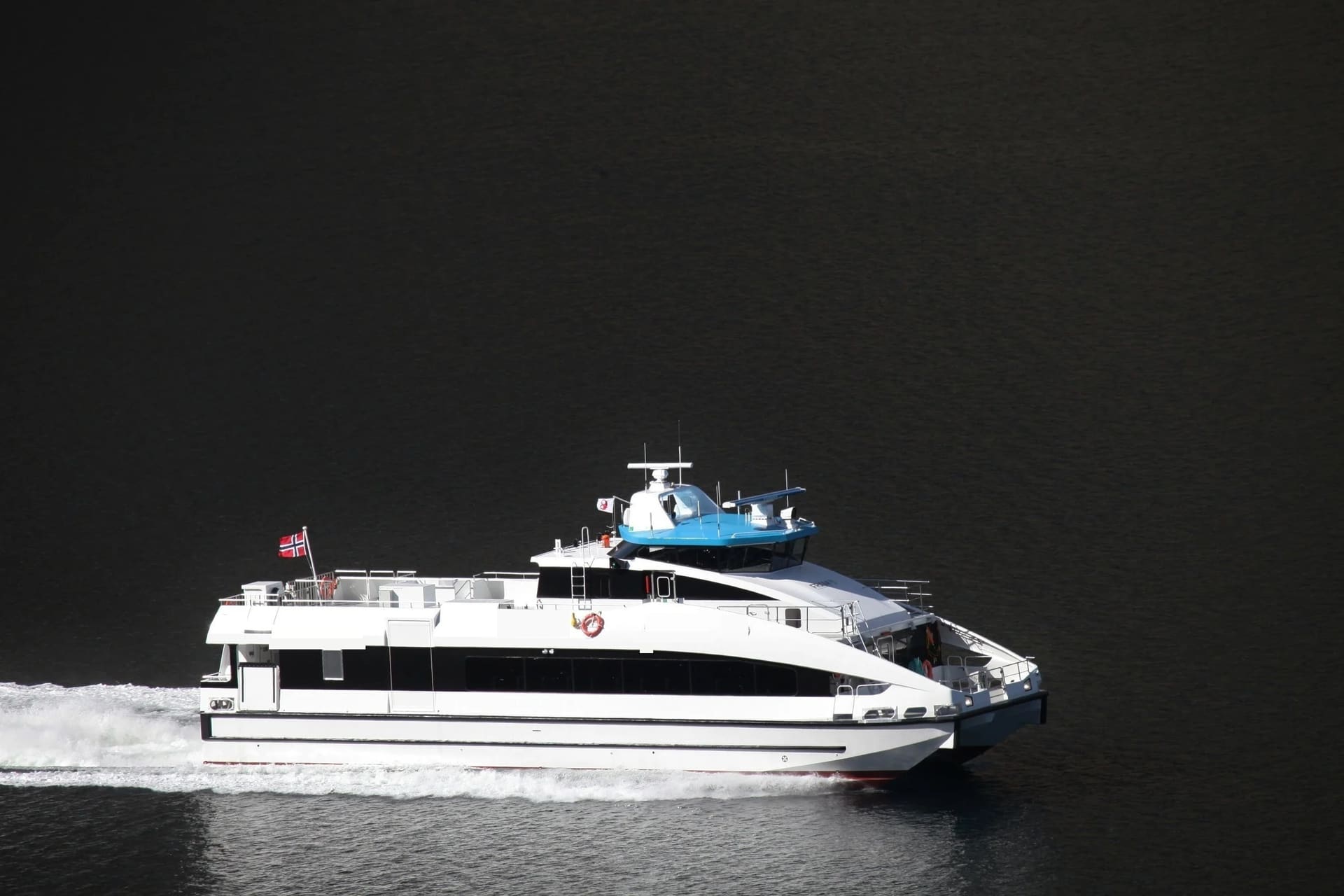 OBLUE FERRY 26 at speed in profile, blue wheelhouse and Norwegian flag