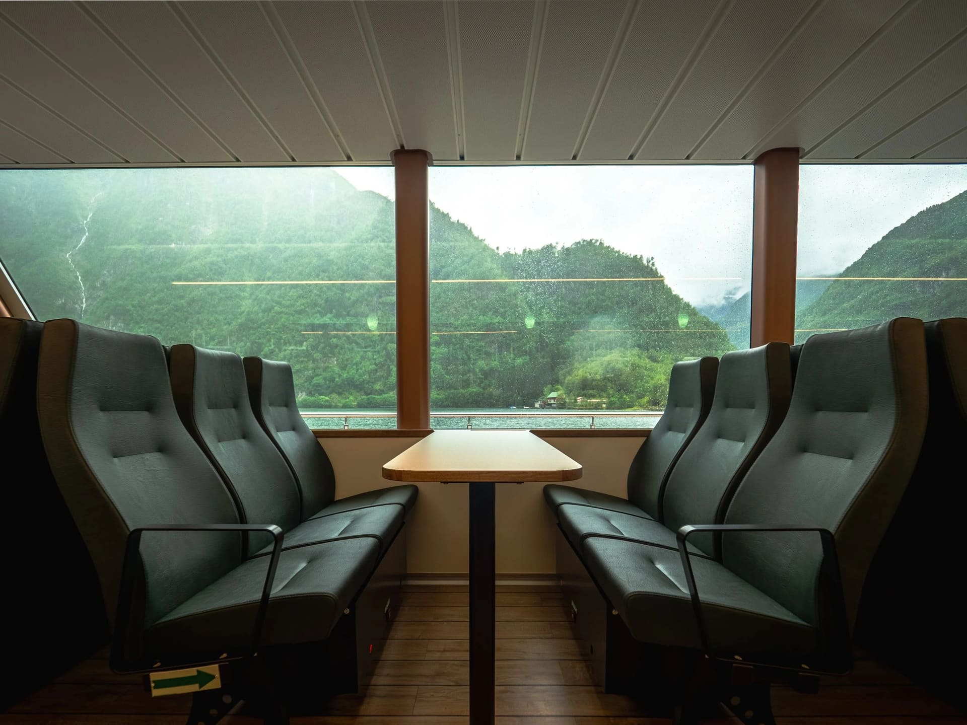 Facing seats with table by the panoramic window, fjord view