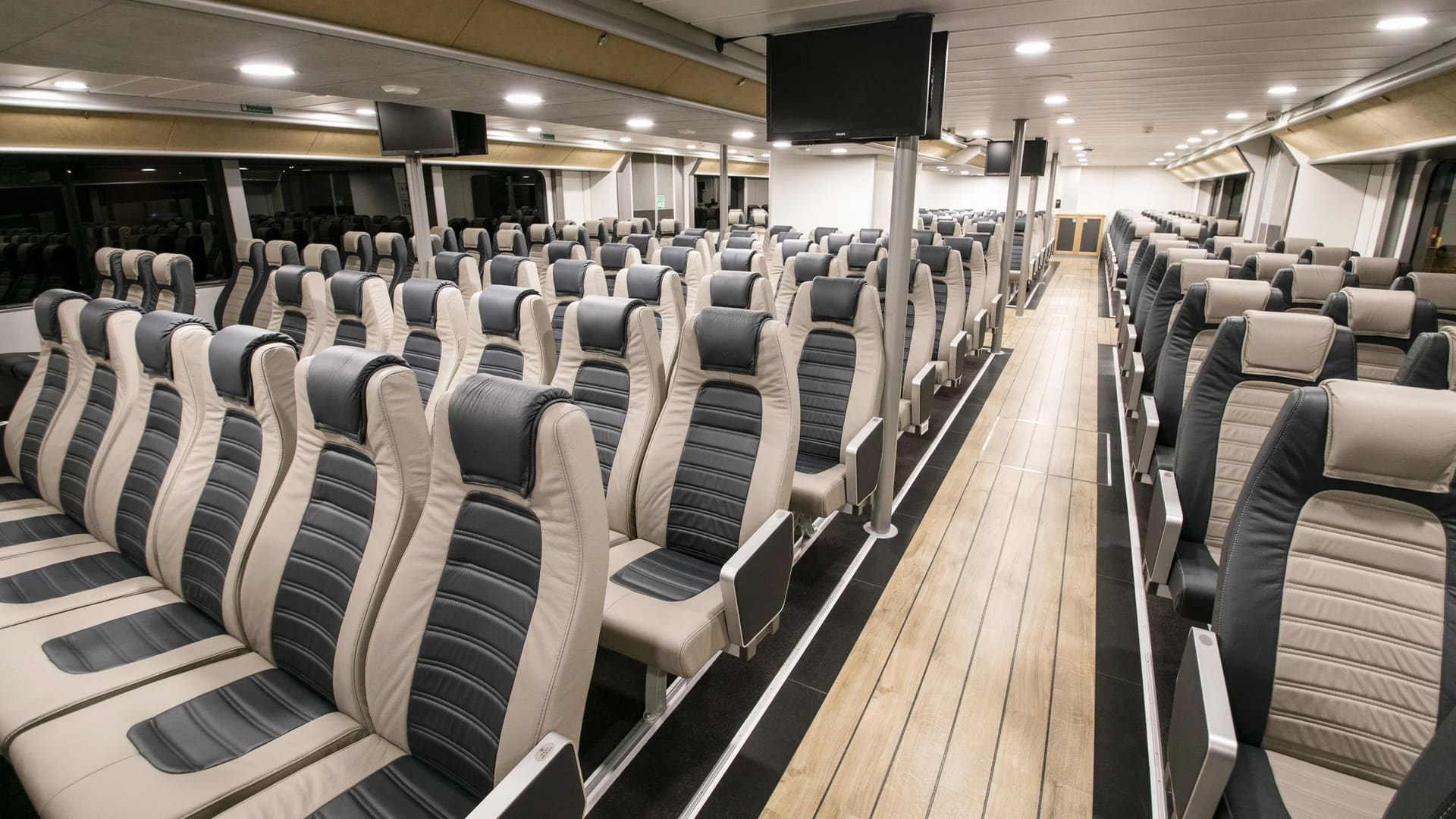 Main saloon of the OBLUE FERRY 32 with two-tone high-back seating along the centre aisle