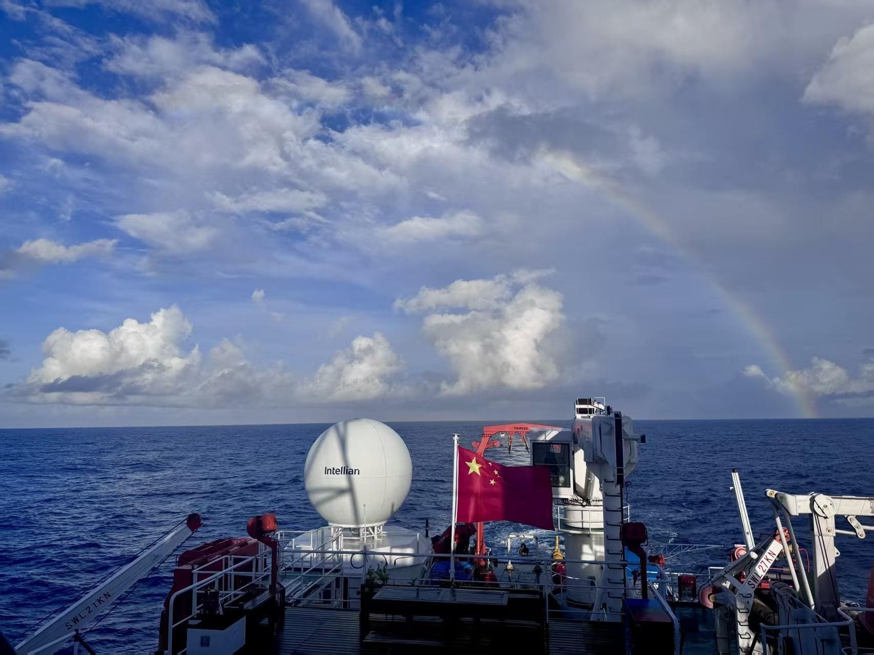 View aft from the FERRY 45 MAX underway — radar dome, flag and a rainbow over the South China Sea